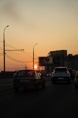 City street at warm sunset with cars and distant buildings Vertical