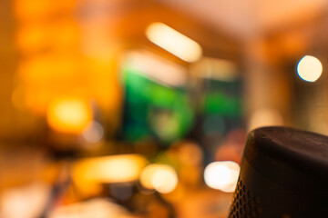 Cozy modern desk setup with warm ambient lighting and green monitor glow, featuring gadgets, keyboard, mic, and gaming chair in a stylish studio workspace. Perfect for background or lifestyle tech the