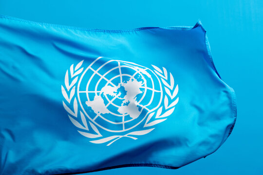 United Nations flag waving on blue background