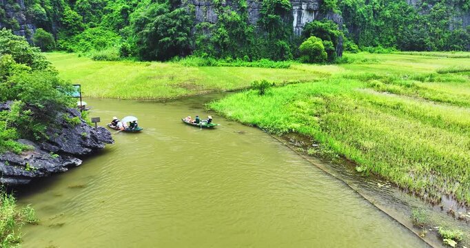 Aerial view of Tam Coc landscape with limestone mountains, river and rice field on stream in Ninh Binh, Vietnam
