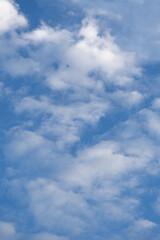 Soft white clouds in bright blue sky vertical