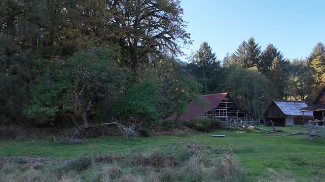 4K smooth footage of Kestner Homestead near Maple Glade Rain Forest Trail in Olympic National Park, USA, showing historic wooden farm buildings, fences, and fall foliage surrounded by evergreen forest