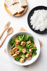 Stir fried tofu and broccoli with soy sauce eating with cooked rice, Asian vegan food, Top view