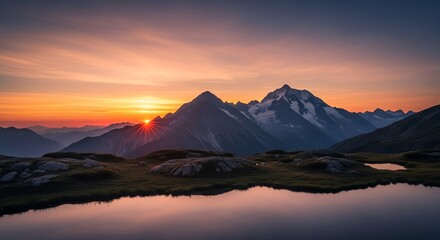 Mountain sunset reflects in lake with snow-capped peaks