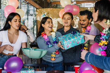 portrait of latin family celebrating in birthday party at terrace outdoors in Mexico Latin America. Hispanic group of people multi age and multicultural eating cake and holding gifts 