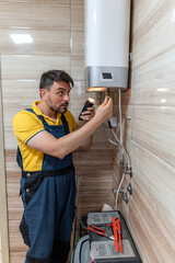 Worker repairs a water heater in a home bathroom during daylight hours