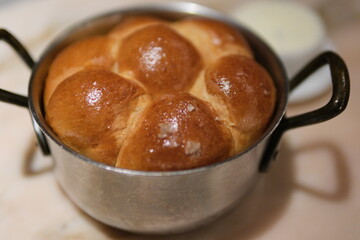 Bread rolls pot variety of fresh baked bread loaves wrapped in country style linens in a basket against rustic brick 