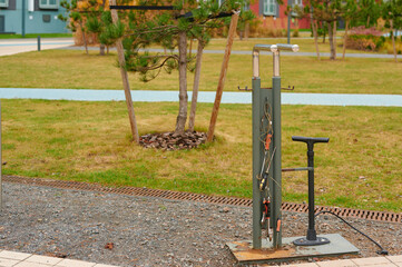outdoor bicycle repair station with tools and air pump in urban park setting, ready for cyclists needing quick maintenance. ideal for eco-friendly, urban transport visuals