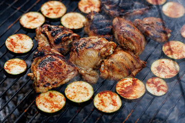 Grilled chicken thighs and zucchini on barbecue