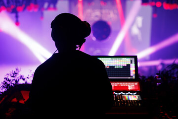 Sound engineer operating control board during live concert