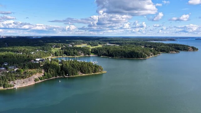 Drone hyperlapse over Finnish Turku Archipelago Sea. Sunny summer weather. Clouds and shadows moving over the scenery. High altitude moving aerial view.