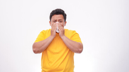 Asian fat man cover his nose and mouth with tissue when sneezing against white background