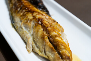 roasted mackerel on a white ceramic dish