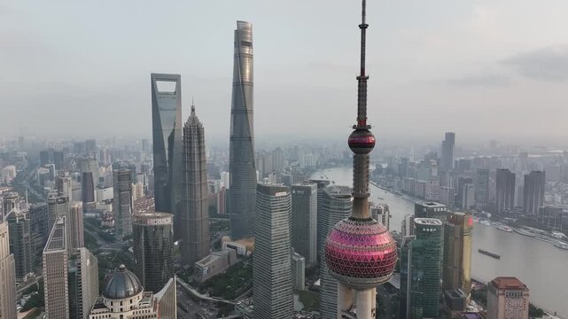 Aerial view of the iconic Shanghai skyline with towering skyscrapers, juxtaposed with the flowing river cutting through the modern cityscape, Shanghai, China.