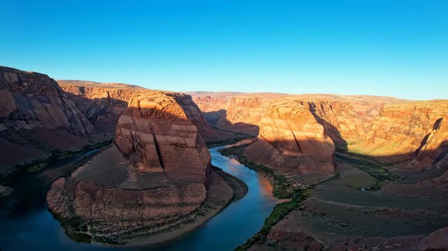 Horseshoe Bend: An expansive aerial perspective of the breathtaking Horseshoe Bend in Arizona, sculpted over millennia by the Colorado River, bathed in the soft hues of the rising sun.