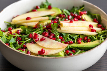 fall salad with arugula apple pomegranate and caramelized pecans close up