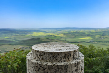 light beige stone pedestal on green hills backdrop. product presentation background with lush green summer landscape and clear sky. 