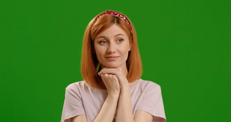 Portrait of thinking and wondering smart woman looks around isolated on green screen background studio. Woman daydreaming being calm and enjoying solitude. Emotion concept.