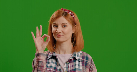 Young cheerful caucasian woman showing ok sign over green screen background Chroma Key