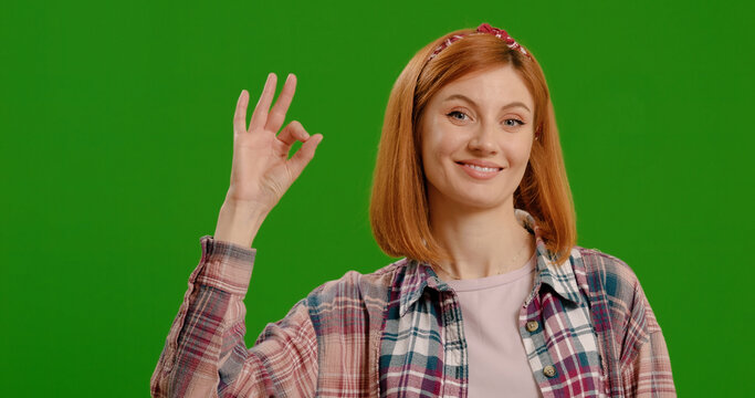 Young cheerful caucasian woman showing ok sign over green screen background Chroma Key
