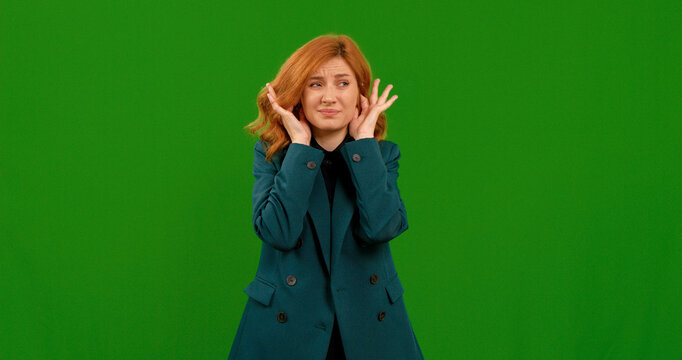A woman with red hair showcases different gestures while standing in front of a green screen. She appears to be demonstrating emotions or reactions in this setting.