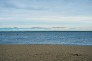 潮芦屋ビーチから見る雲の切れ間に見える山並みのシルエット