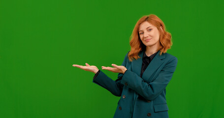 A young woman in a green blazer is showcasing different hand gestures in a bright green space, expressing creativity and engagement during a presentation.