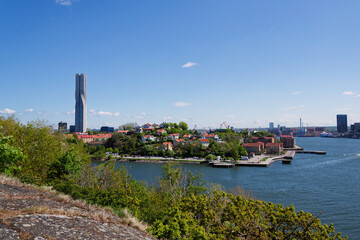 Colony of small wooden historic houses on the Slottsberget mountain with the tallest Scandinavian building Karlatornet skycraper in Lindholmen, Gothenburg, Sweden