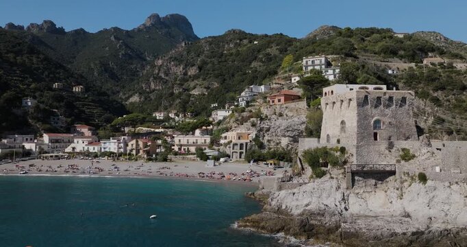 Aerial view of Erchie, a coastal village dominated by Torre La Cerniola, where architecture meets the sea against a backdrop of lush mountains, Erchie, Amalfi Coast, Italy.