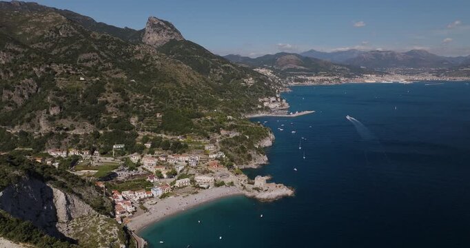 Aerial view of Erchie's vibrant coastline, showing the town's buildings and the blue sea filled with boats contrasting with the green mountains, Erchie, Amalfi Coast, Italy.