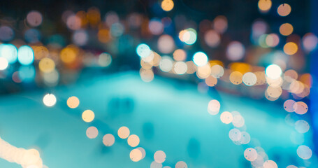Defocused group of people skating on ice in Christmas park. People skating on ice skating rink in...