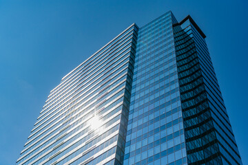 Fototapeta premium Architectural building business area. Glass skyscraper. City architecture. Architecture of office building. Perspective skyscraper. Minimalist architecture. Business skyscraper building. Modern city