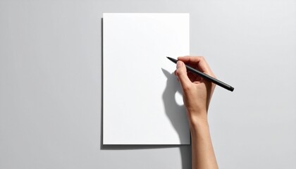 Hand writing on blank white paper with a black pen on a white surface.