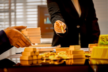 A suited Asian analyst confirms the tangible value of global gold holdings, carefully placing a...