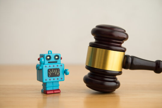 Hammer judge gavel and AI artificial intelligence bot on wooden table with white wall background copy space. Artificial intelligence AI law, regulation, act concept.