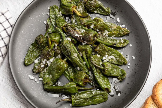 Top view of Spanish traditional food grilled green padron pepper with salt