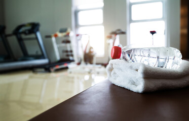 Water and towels on the gym bench