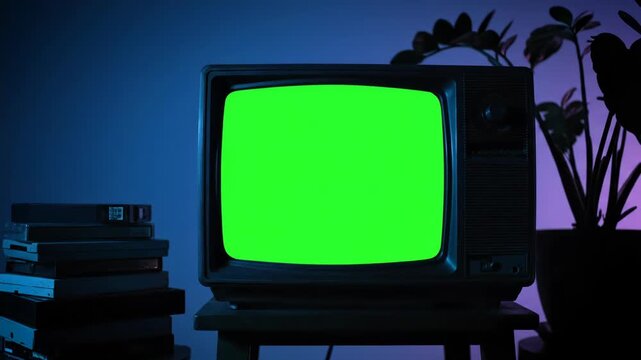 An old television with a bright green screen, illuminated by blue and purple ambient light, with a stack of vhs tapes beside it vector illustration