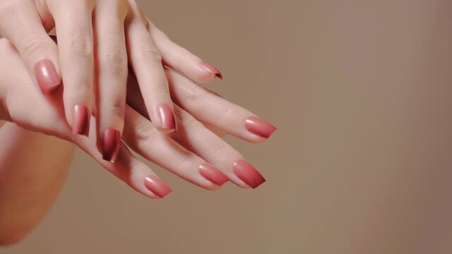 Slow-motion of elegant hands with red nails together in a delicate choreography, highlighting nail shape with manicure, shellac polish. Feminine grace suitable for beauty brands and product showcase