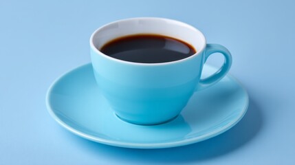 Obraz premium A bright blue ceramic coffee cup filled with dark, aromatic coffee sits on a matching saucer. The scene presents a modern and calming atmosphere, perfect for a quiet moment