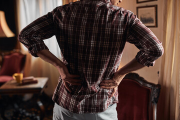 Man with hip, back and sciatica pain at home.