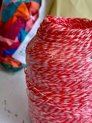 Close-up of red and white twine roll used for packaging or crafts