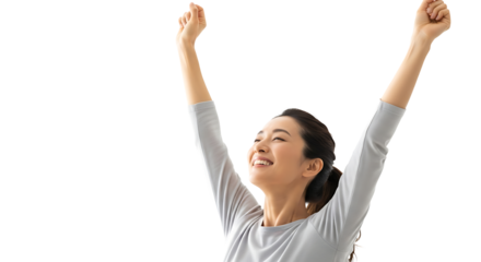A young woman with brown hair, raising her arms in joy, expressing success and freedom.  She is wearing a casual gray top.