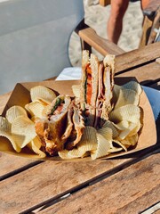 Club sandwich with chips on wooden table