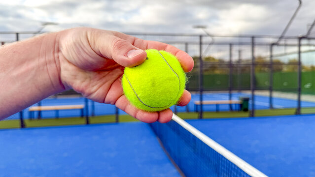 A hand poised with a neon tennis ball, whispers of Wimbledon dreams, flair of Singles' Day sporting joy