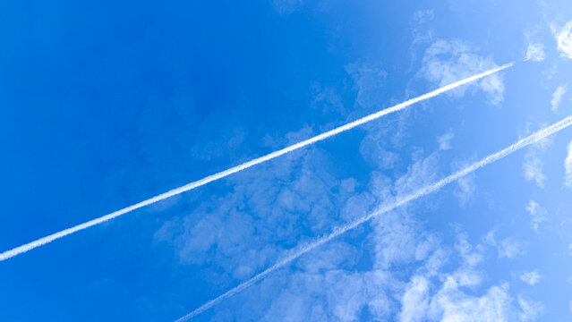 Wispy contrails slice azure sky like a cosmic canvas, evoking World Meteorological Day and poetic aerodynamics appreciation