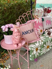 Romantic outdoor decor with pink bench and love themed pillows