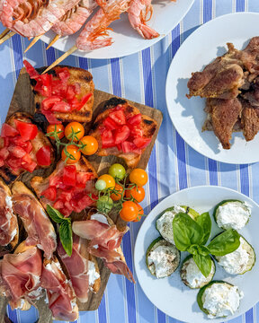 Mediterranean feast of sunlit bruschetta, crimson prawns, and herb-riddled cheese bites, perfect for Ferragosto or Bastille Day