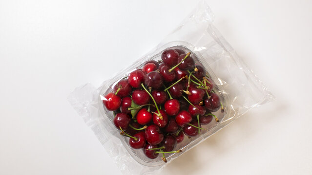 Vibrant cherries nestled in recyclable plastic evoke summer solstice feasts and ancient Slavic Kupala Night rituals, sweetly beckoning