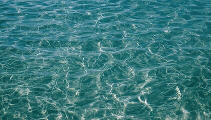 Obraz premium Clear water body with sunlight creating ripples on the surface